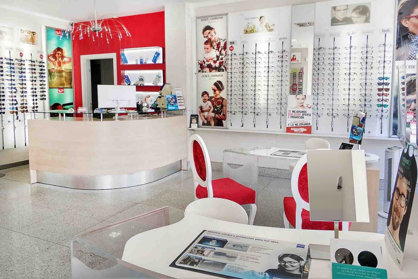 Interior de la óptica Lentes de Oro, con el mostrador y las sillas rojas